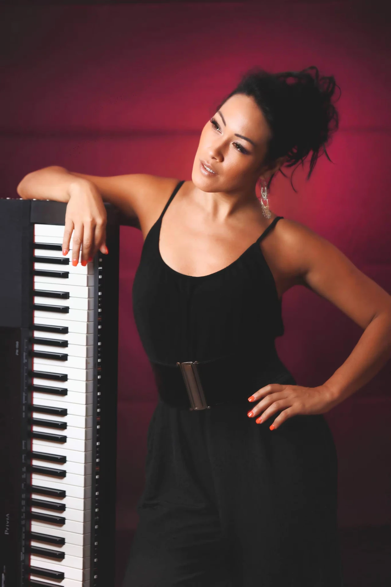 Melina Soochan in a black dress beside a keyboard