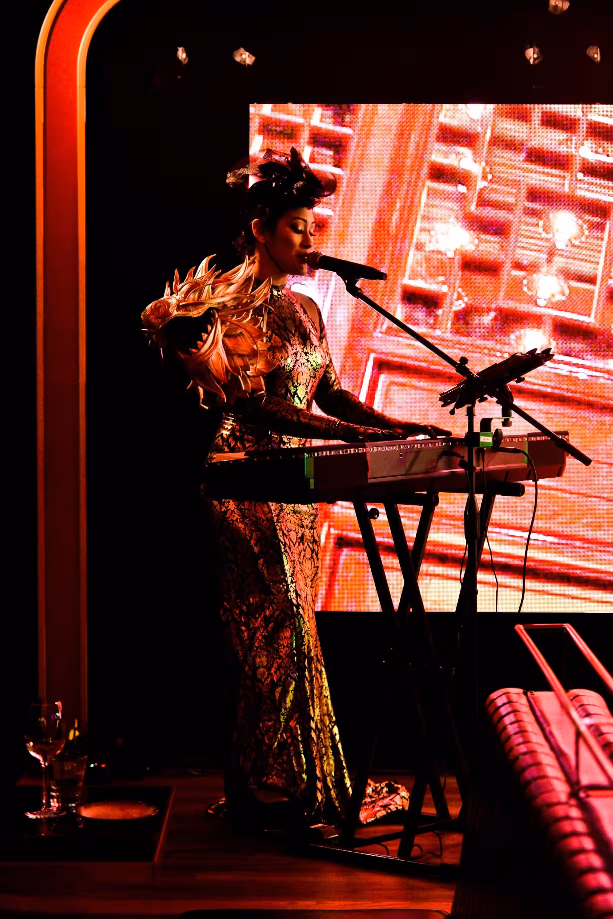 Melina Soochan singing and playing keyboard during a live performance